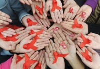 University students hold red ribbons at a photo opportunity during an HIV/AIDS awareness rally on World AIDS day in Chengdu